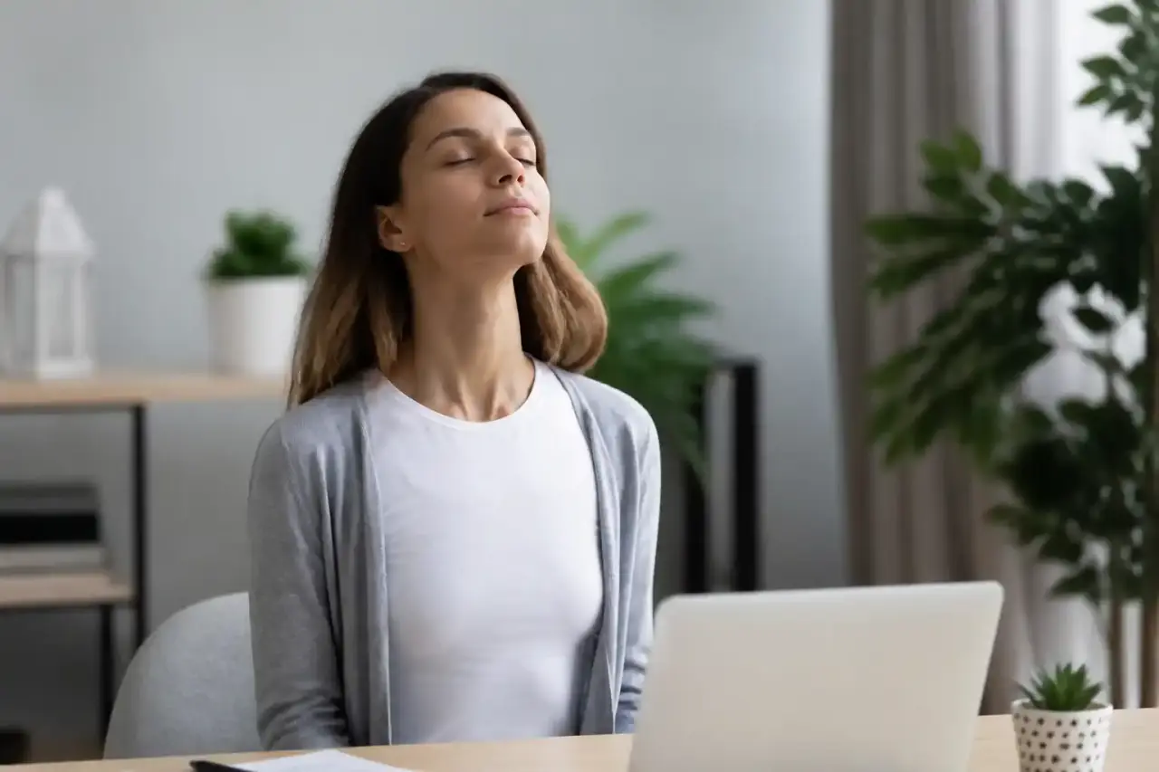 Personne de profil inspirant profondément les yeux fermés, sur un fond neutre et lumineux